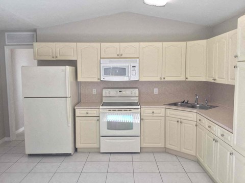 a kitchen with white appliances and white cabinets