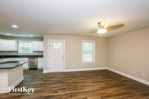 A kitchen with a wooden floor and a ceiling fan.
