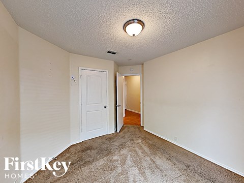 a bedroom with carpeted flooring and a door to a hallway