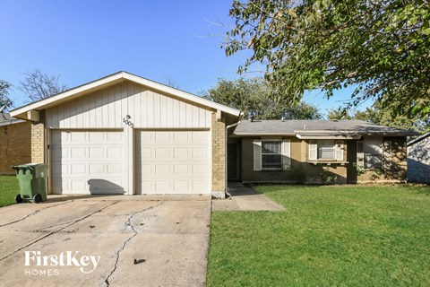a white garage door on a brick house with a driveway