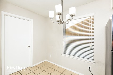 a dining room with a window and a light fixture on the ceiling