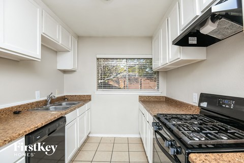 a kitchen with a stove and sink and a window
