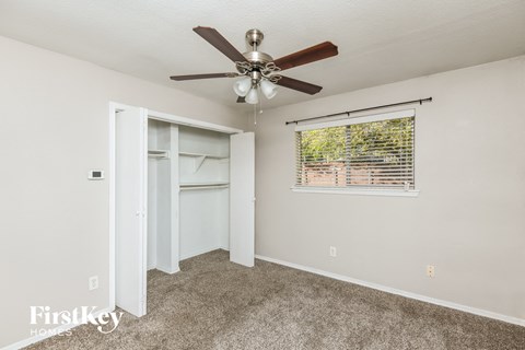 a bedroom with a ceiling fan and a window