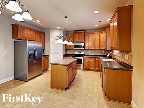 A kitchen with wooden cabinets and a refrigerator.