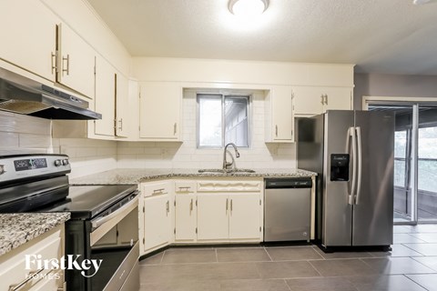 a kitchen with white cabinets and stainless steel appliances