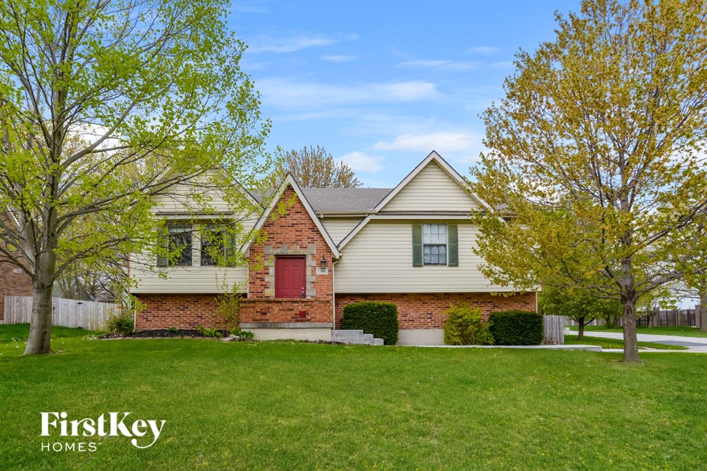 a home with a green lawn and a red door