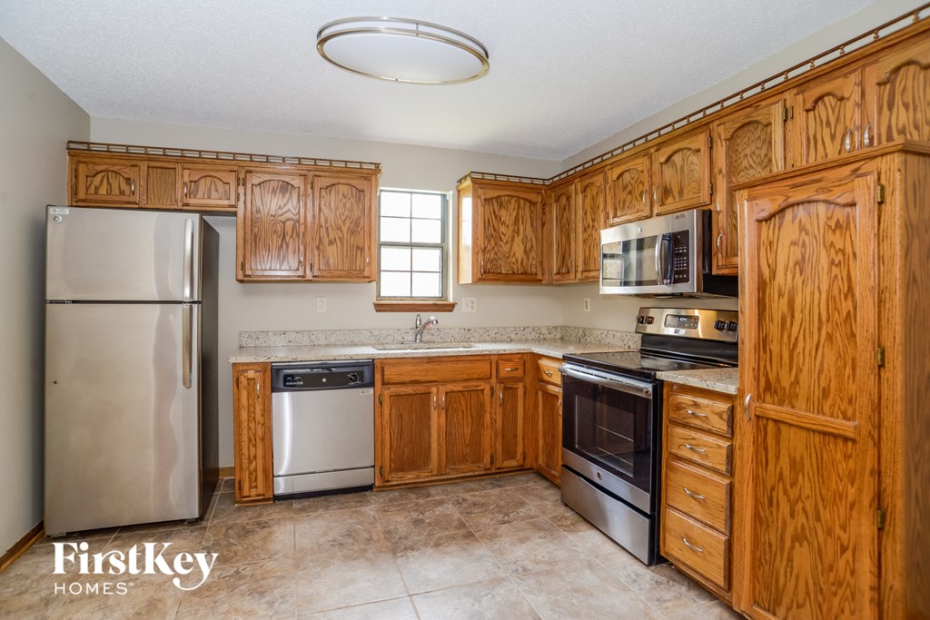 a kitchen with wooden cabinets and stainless steel appliances