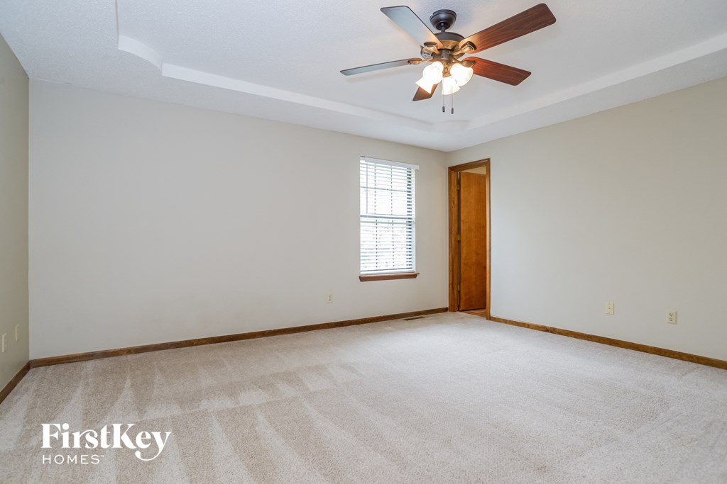 the living room of an empty house with a ceiling fan