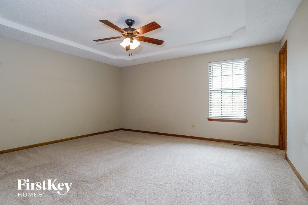 the living room of an empty house with a ceiling fan