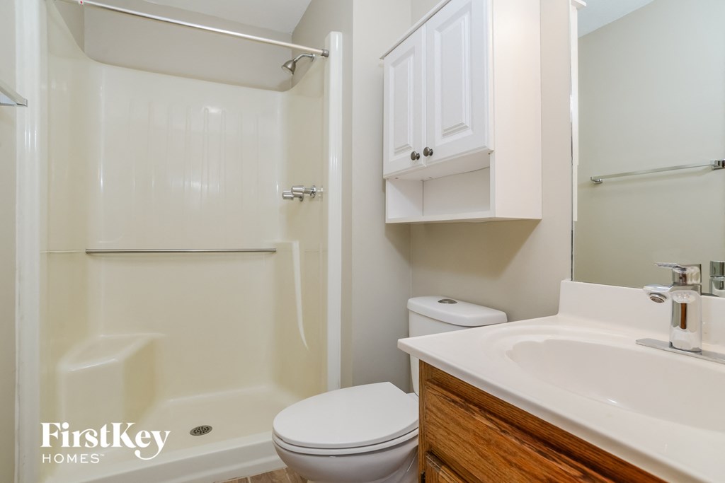 a bathroom with a toilet and a sink and a shower