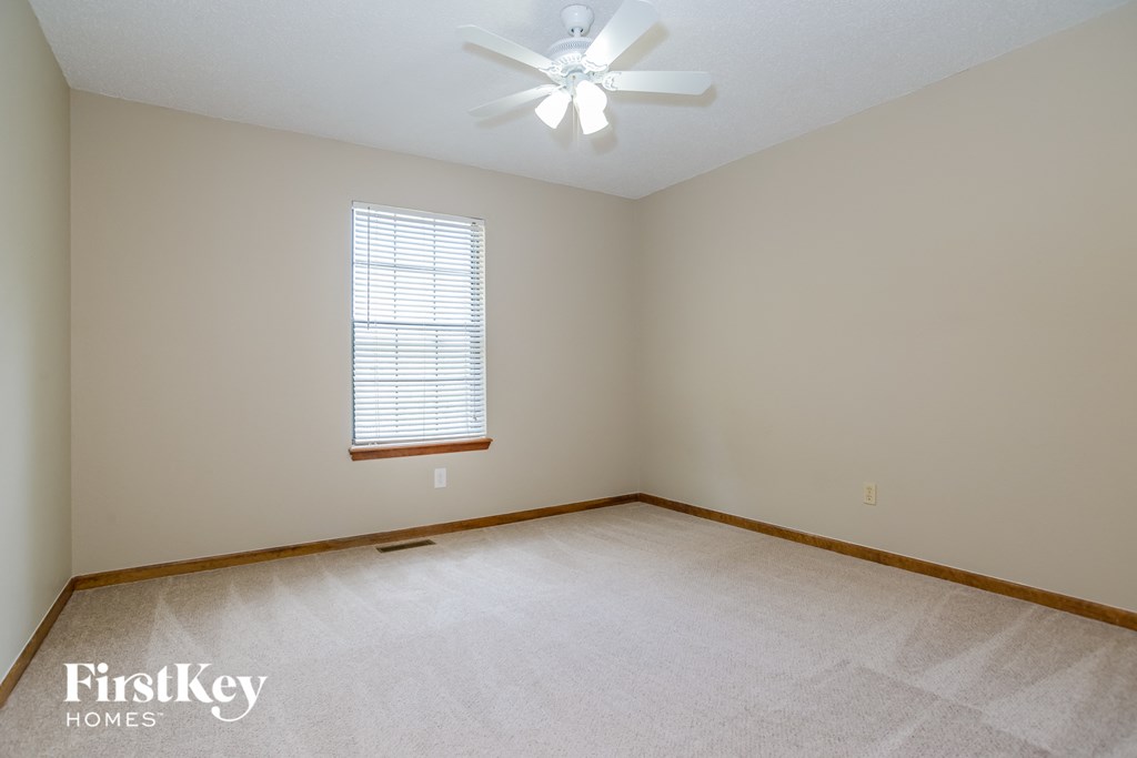 a bedroom with a white carpet and a ceiling fan