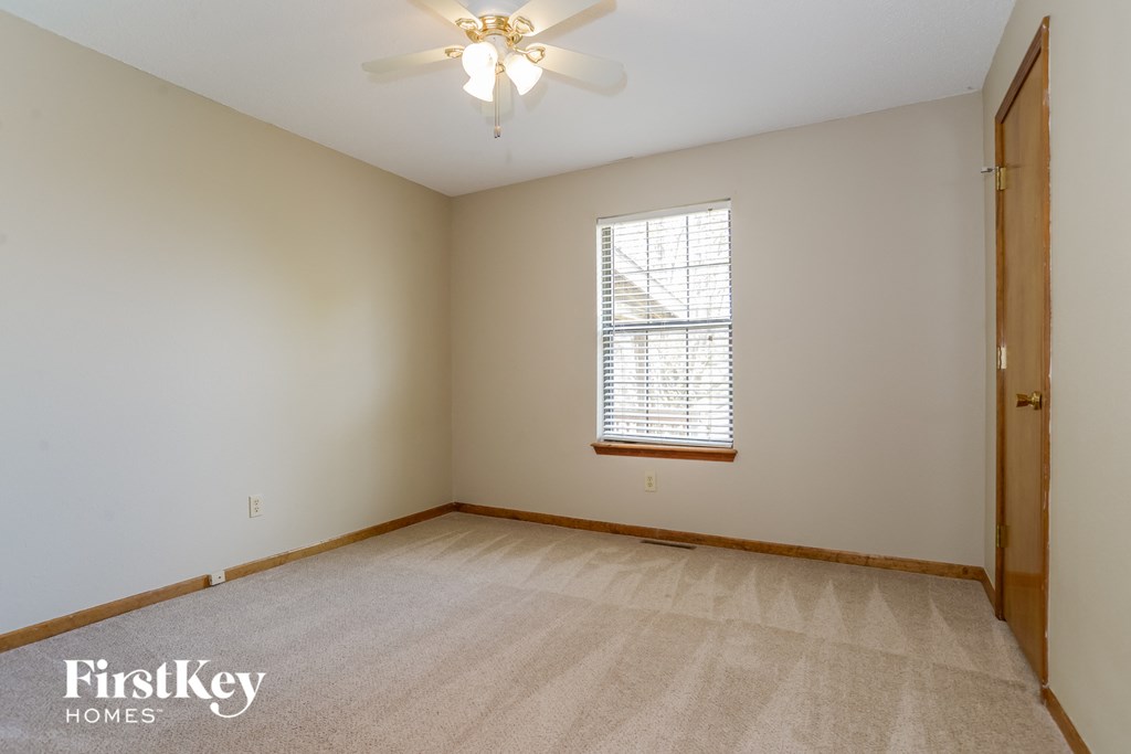 the living room is spacious and clean with a ceiling fan
