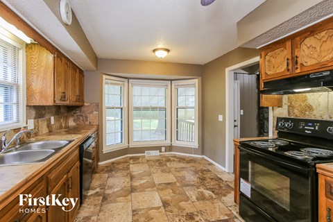 A kitchen with wooden cabinets and a black stove top oven.