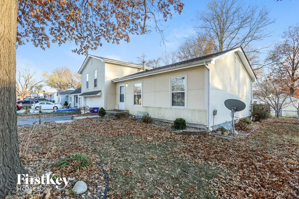 a white house with a yard and a tree