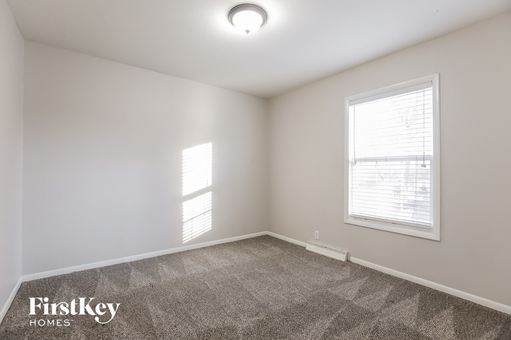 a bedroom with a carpeted floor and two windows