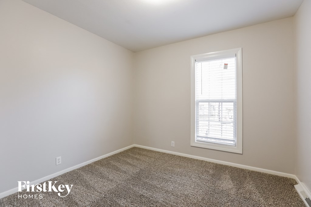 a empty room with a window and carpet