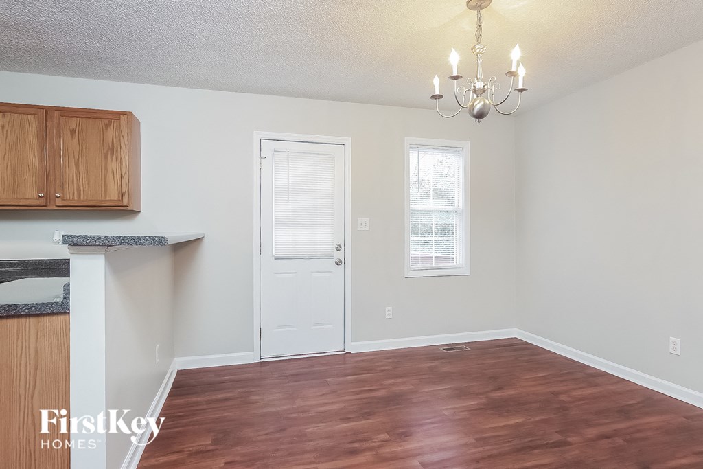 an empty living room with wood flooring and a white door