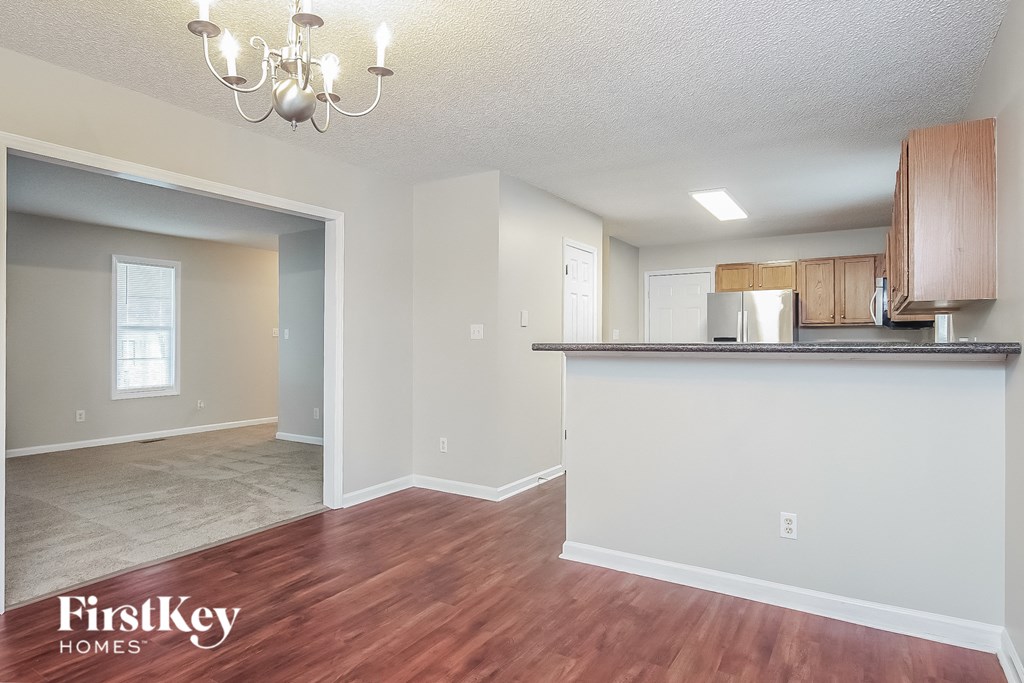 a living room with a kitchen and a hard wood floor