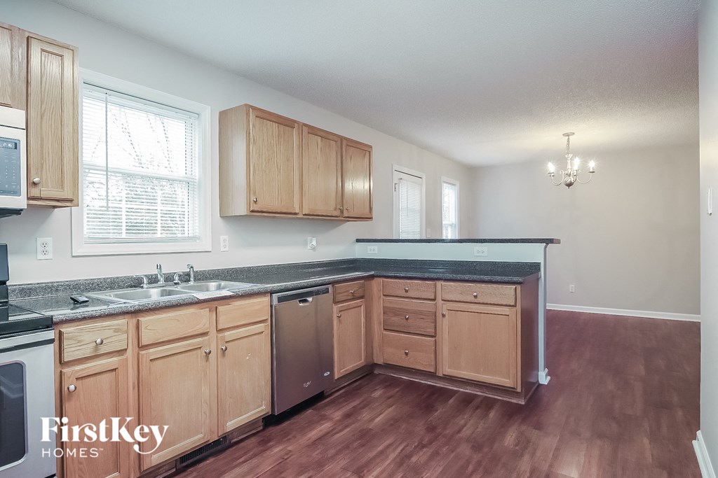 a kitchen with wood floors and wooden cabinets and a sink