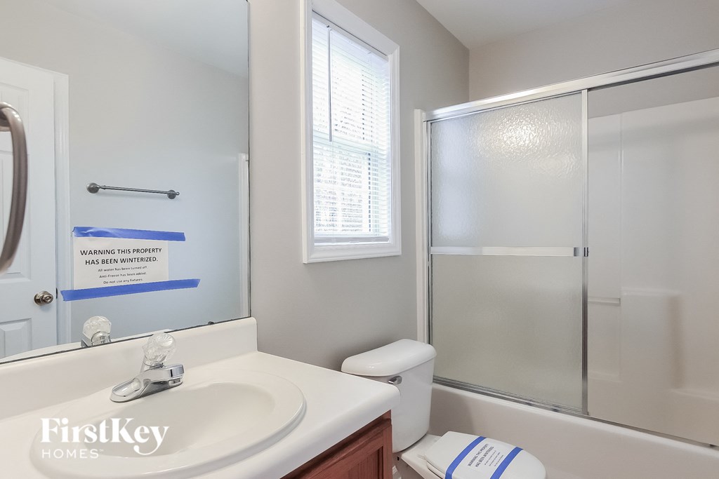 a bathroom with a shower sink and toilet and a mirror