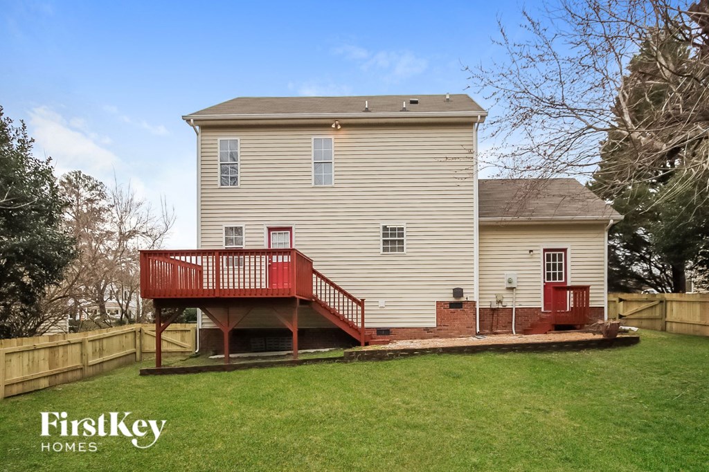 the back of a house with a red porch and a deck