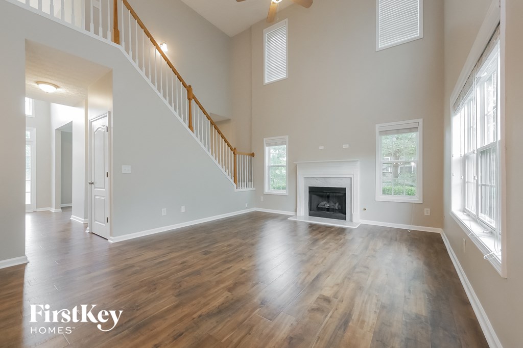 A spacious living room with wood flooring and a fireplace.