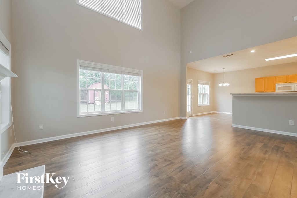 A spacious room with wooden floors and a large window.