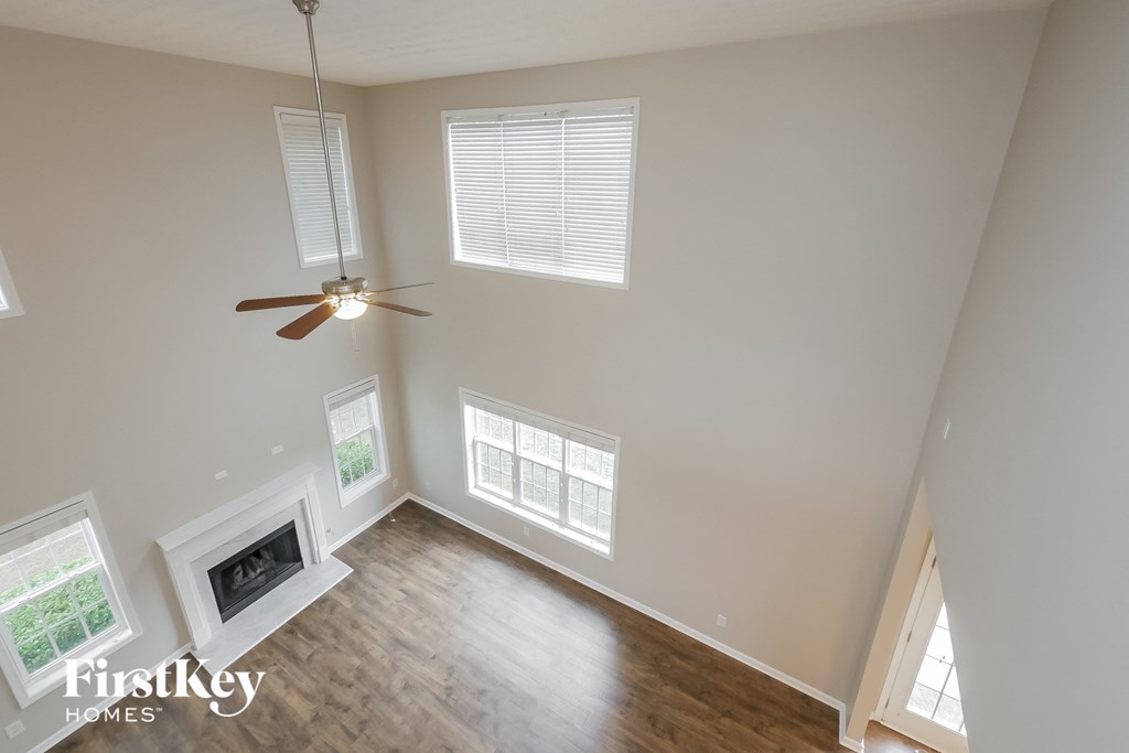 A room with a fireplace and a ceiling fan.