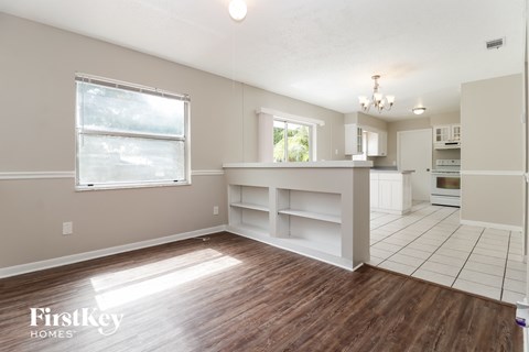 a kitchen and dining room with white cabinets and a wood floor