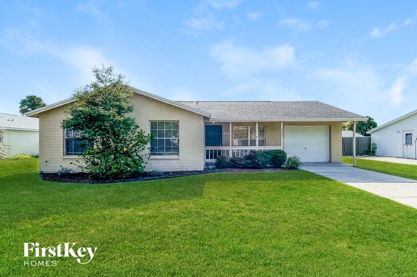 A house with a well-maintained lawn and a clear sky above.