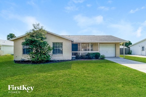 A house with a well-maintained lawn and a clear sky above.