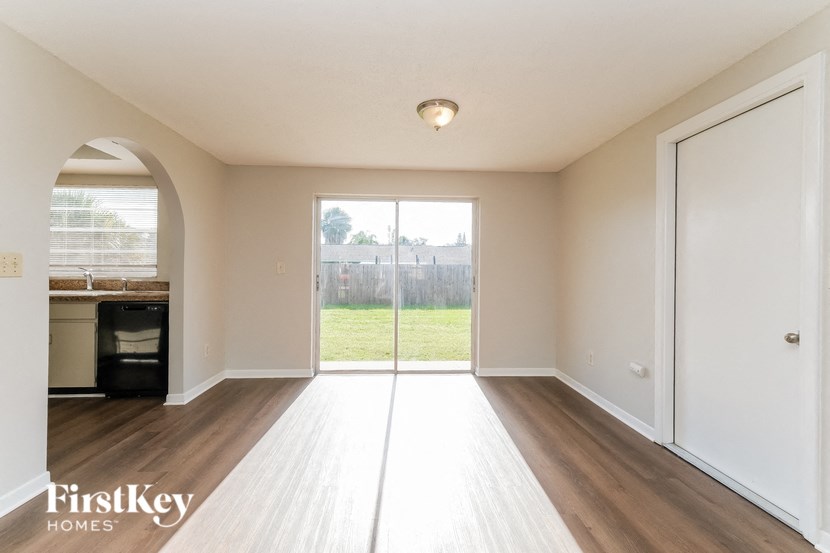 A spacious room with a sliding glass door leading to a balcony.