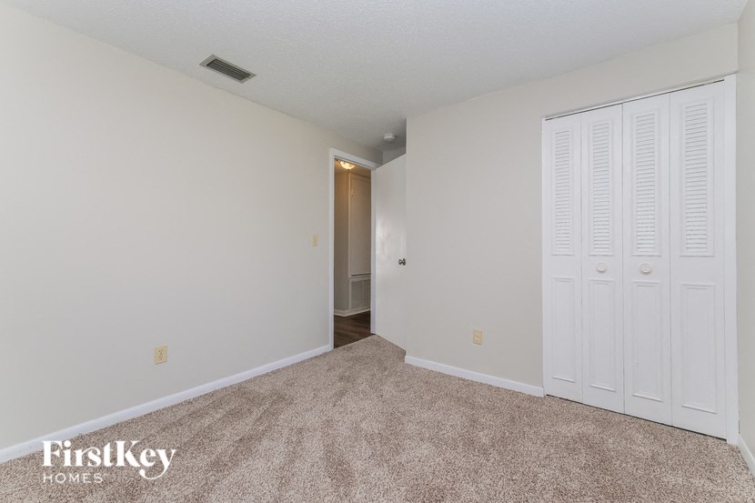 A room with a carpeted floor and a white door.