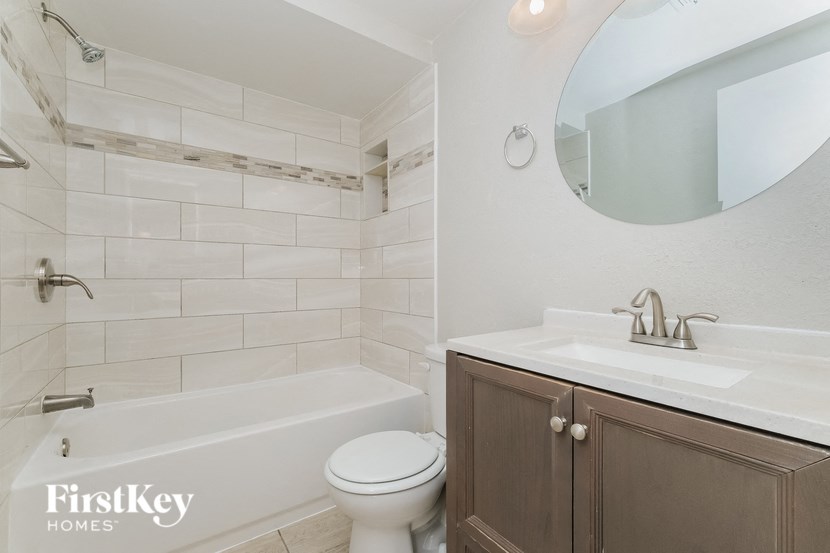A bathroom with a white tub, sink, and toilet.
