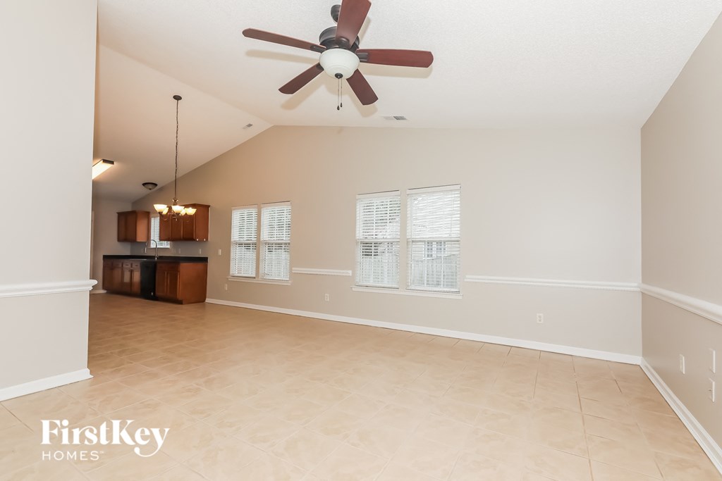 A spacious room with a ceiling fan and a cabinet.