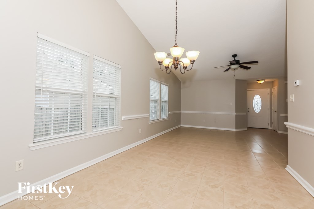 A spacious room with a chandelier and a ceiling fan.