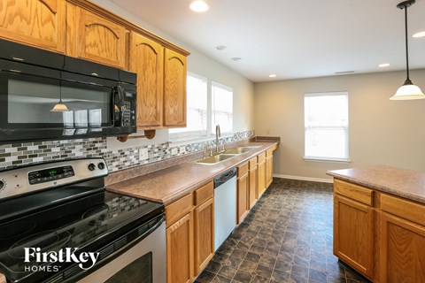 A kitchen with wooden cabinets and a black stove top oven.