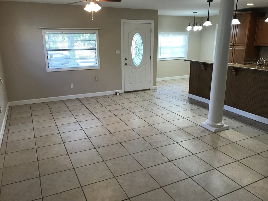 A room with a tile floor and a door with a circular window.