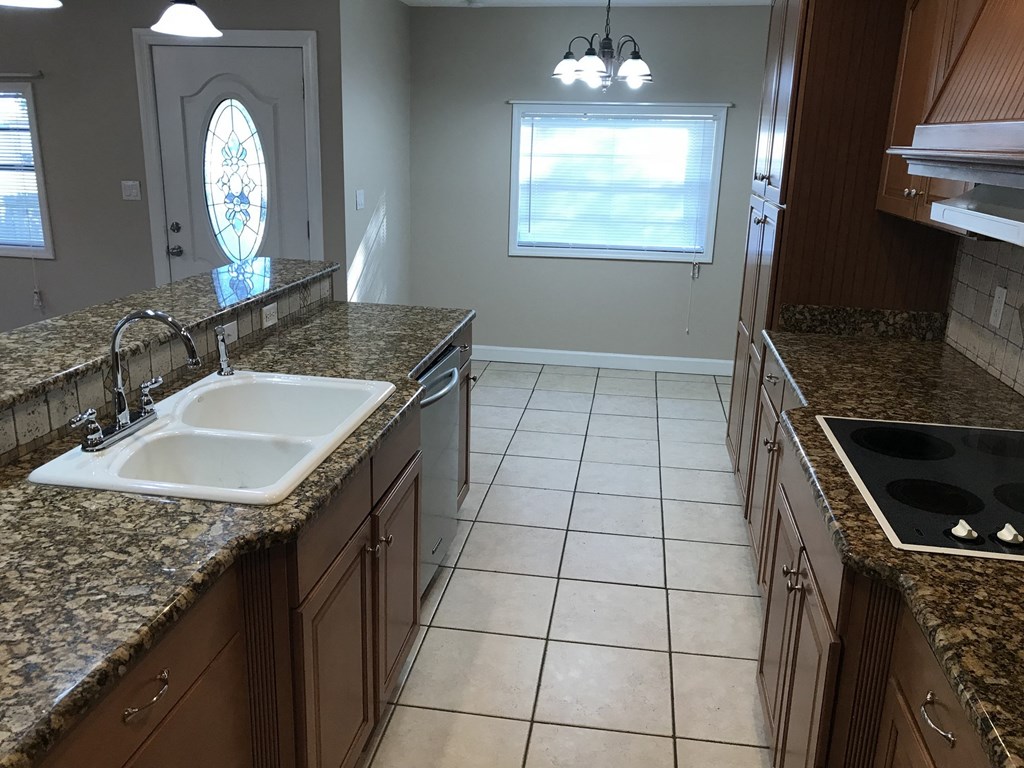 A kitchen with granite countertops and a white sink.