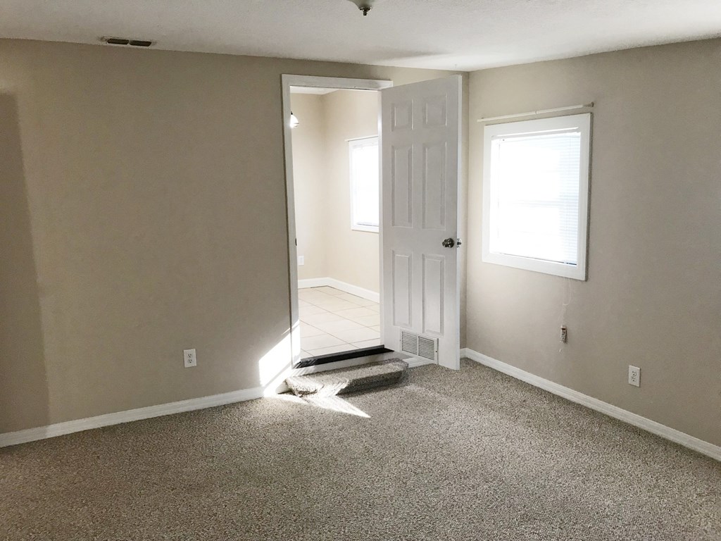 A room with a white door and a window.