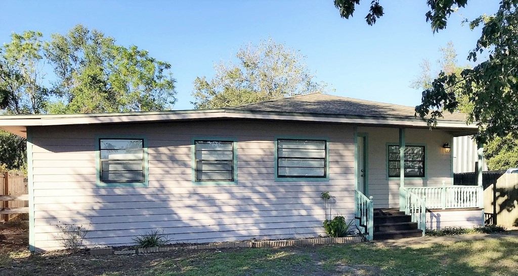 A small house with a white siding and a green door.