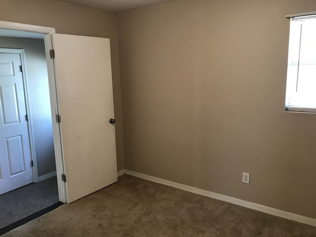 A room with a white door and a window.