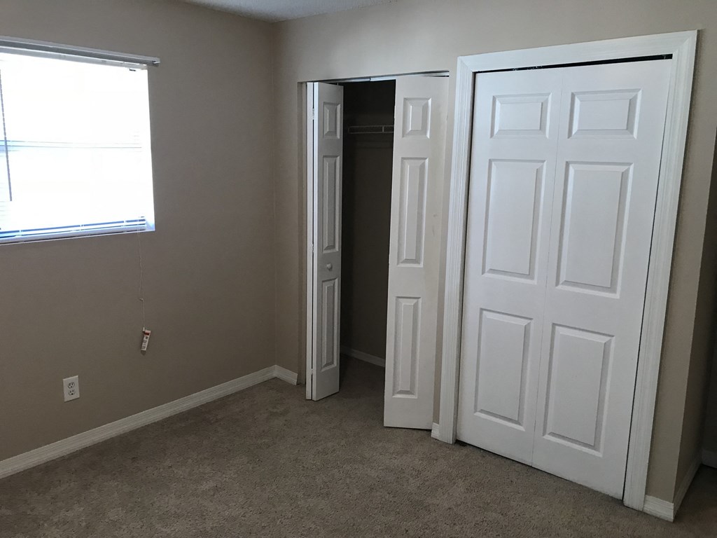 A room with a white door and a window.