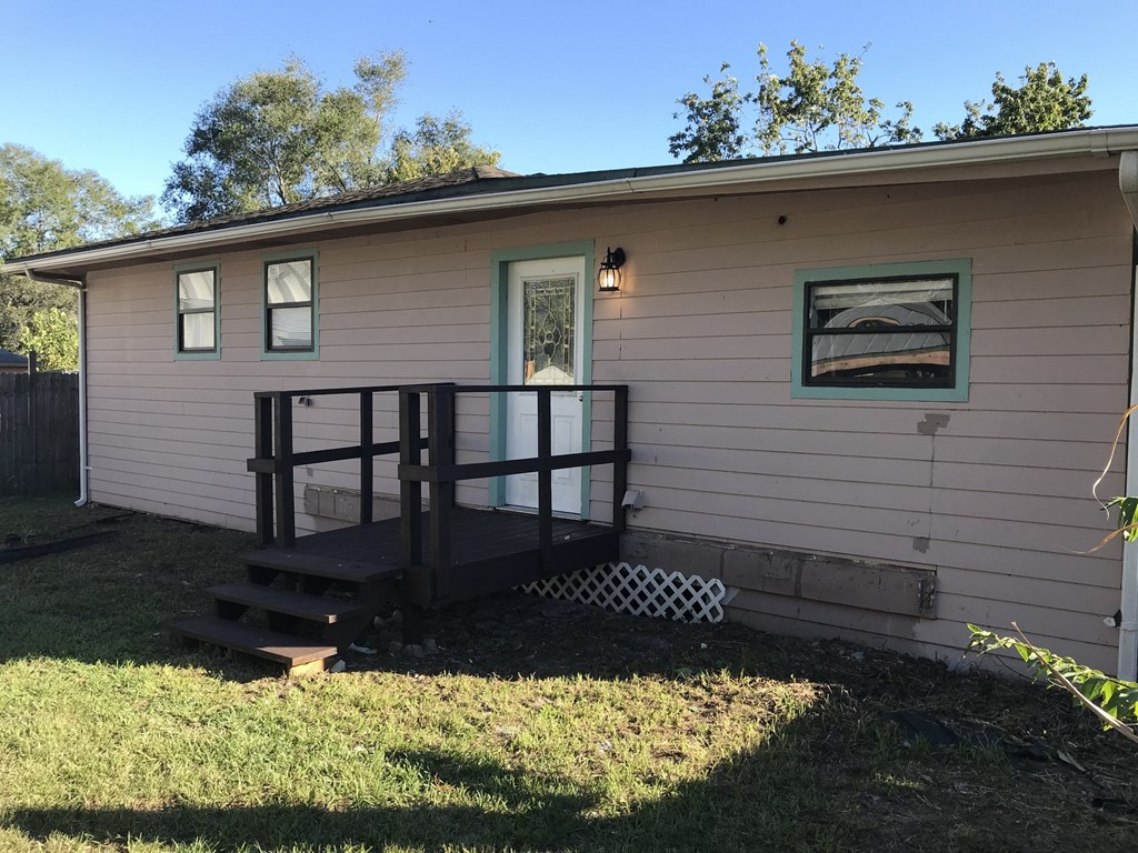 A small house with a porch and a green window.