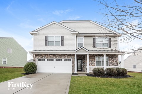 a white and brick house with a white garage door