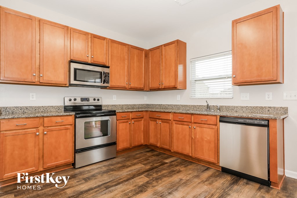a kitchen with wooden cabinets and granite counter tops and stainless steel appliances