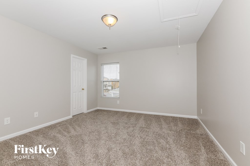 a spacious living room with carpet and a white door