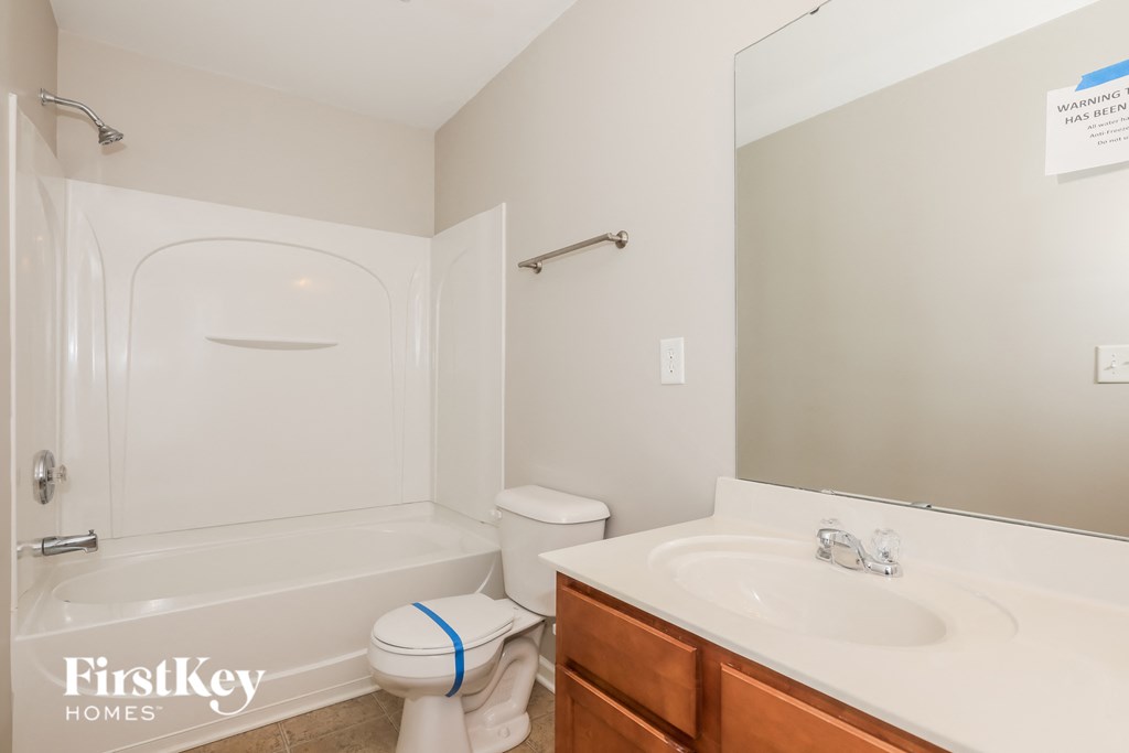a bathroom with a sink toilet and tub and a mirror