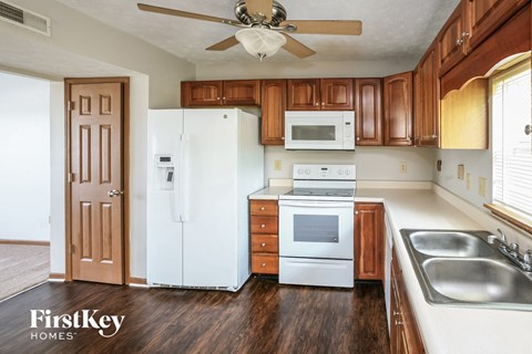 a kitchen with white appliances and wooden cabinets