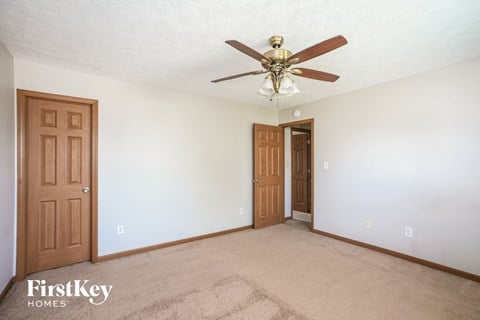 a bedroom with a ceiling fan and a door to a closet